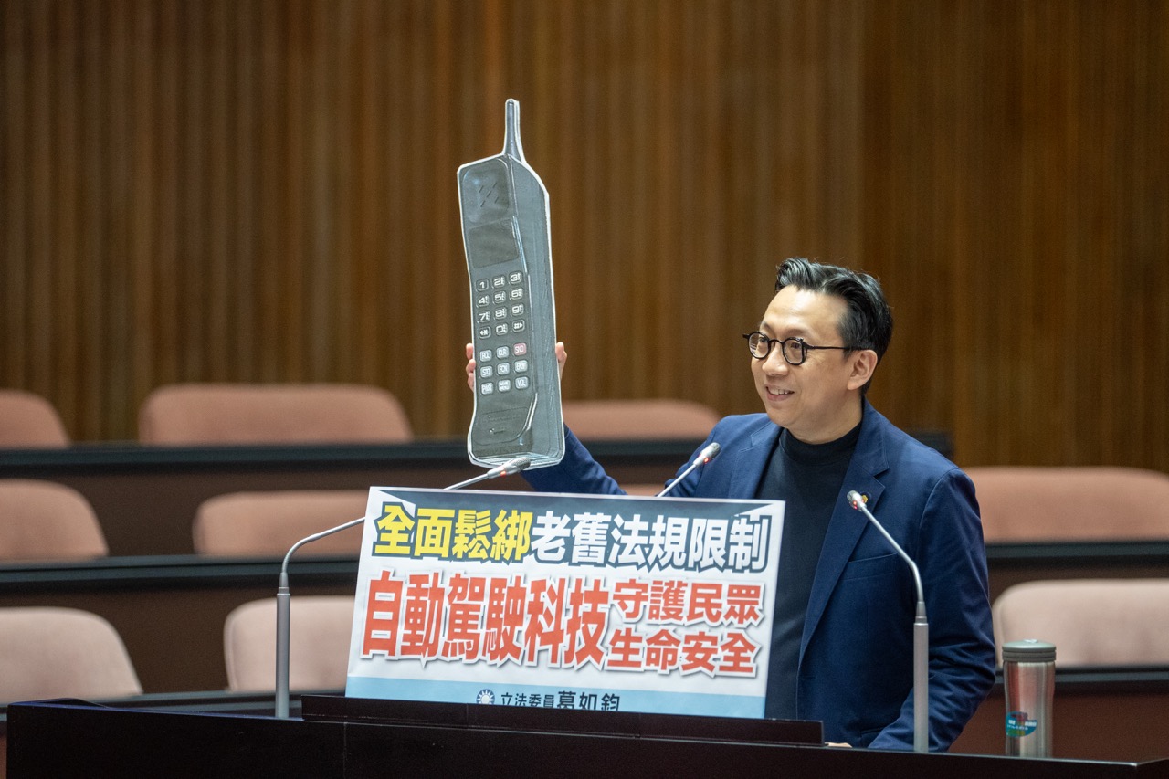 Legislator JU CHUN KO holds a brick phone during a Legislative Yuan general inquiry to call for autonomous driving regulatory reform