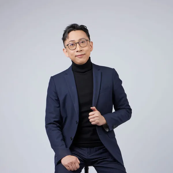 Ju-Chun Ko in a navy suit: seated portrait
